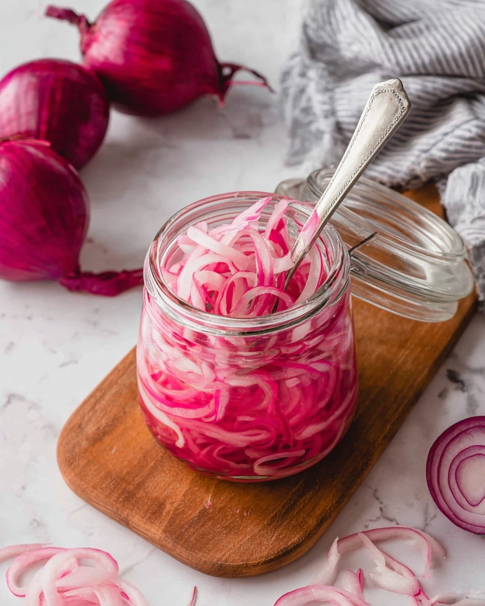 A clear glass jar filled with bright pink thinly sliced pickled onions, packed tightly and layered unevenly inside the jar. The onions have a shiny, wet texture with some pieces curled and overlapping on top. The jar features a black metal clasp lock at the front, which is slightly worn and adds contrast to the vivid color of the onions. The jar sits on a white marbled surface, providing a clean, light background that highlights the rich pink color of the onions. photo taken with an iphone --ar 4:5 --v 7