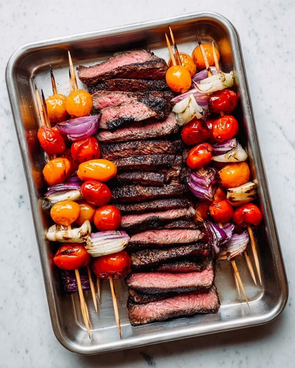 A metal tray holds a serving of grilled steak slices and vegetable skewers. The steak is cut into thick layers, showing a pink inner color with a slightly charred dark brown crust on the outside, arranged in a stacked pattern in the middle of the tray. On both sides of the steak are wooden skewers loaded with grilled cherry tomatoes in red and orange, mixed with slightly charred white onion pieces and some purple onion slices, adding a colorful contrast. The tray is placed on a white marbled surface. photo taken with an iphone --ar 4:5 --v 7