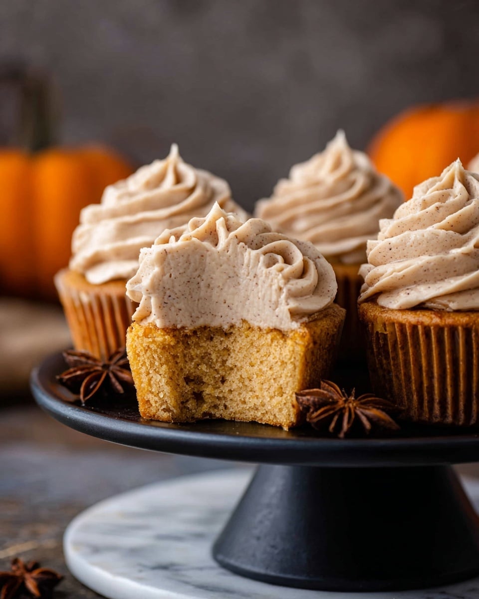 A clear glass bowl filled with smooth, creamy yellow batter swirled evenly inside, set on a white marbled surface. Around the bowl, there are small decorative pumpkins in orange and white colors, scattered softly in the background and foreground. The texture of the batter looks light and fluffy, with gentle peaks and soft folds, giving a sense of readiness for baking. Photo taken with an iphone --ar 4:5 --v 7