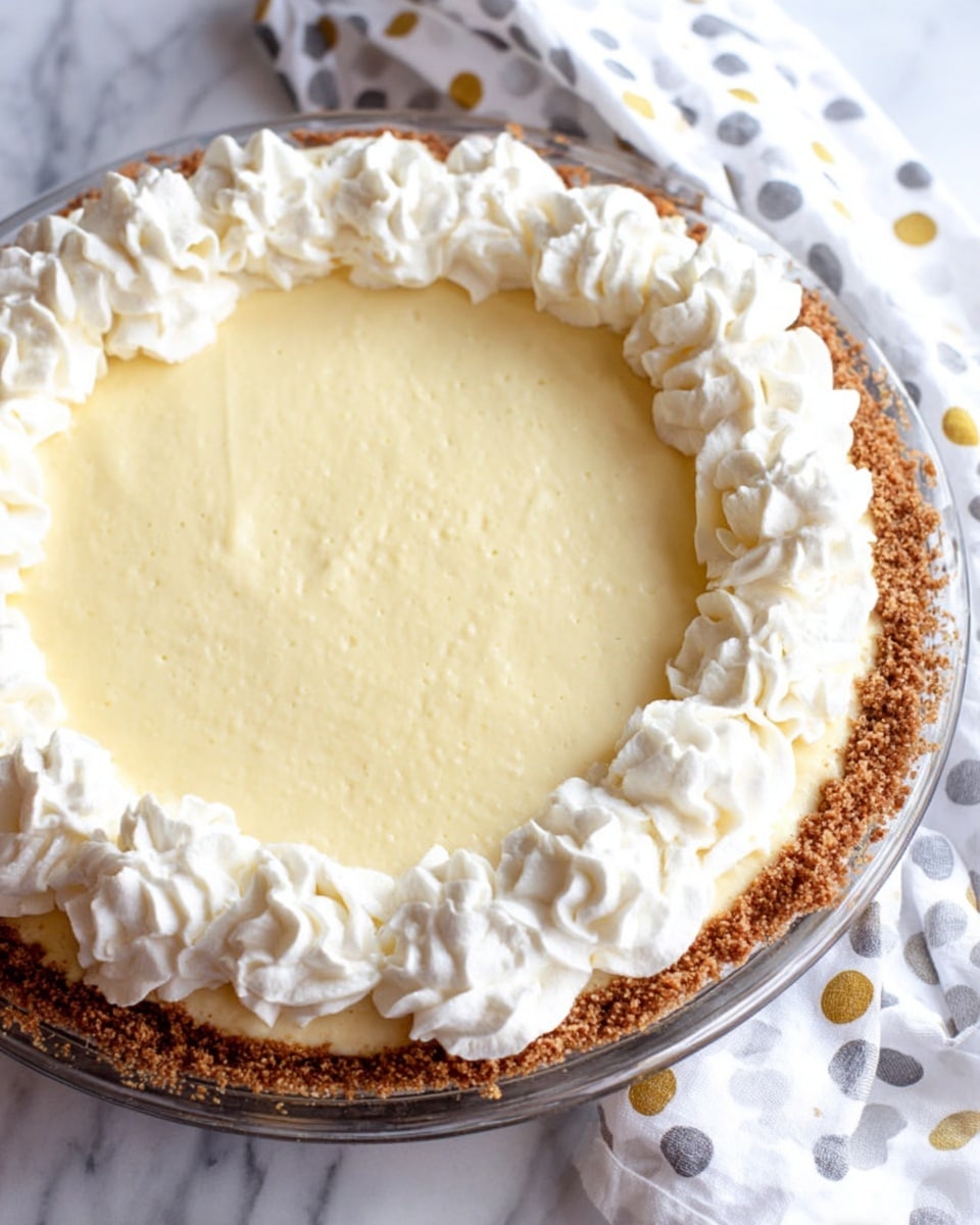 A thick slice of pale cream cheesecake sits on a white plate, showing three clear layers: a thin brown crumbly crust at the bottom, a tall smooth creamy middle layer with a light beige tint, and a top layer of soft white whipped cream dollops with specks of cinnamon dusted over. In the background, the full cheesecake is visible on a white plate, matching the slice's colors and layers, all placed on a white marbled surface. photo taken with an iphone --ar 4:5 --v 7