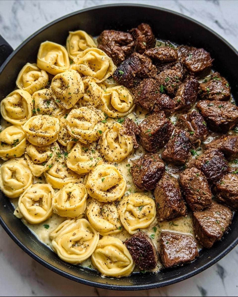 The image shows a close-up of a white bowl filled with a creamy sauce dish containing round, plump tortellini pasta with a smooth, pale yellow color, mixed with chunky pieces of browned beef. The creamy sauce is thick and light beige, surrounding the pasta and beef evenly. The beef pieces are rich brown with a slightly rough texture, scattered throughout the bowl. There are small green herb bits sprinkled on top along with cracked black pepper, adding specks of dark color contrast. The bowl is placed on a white marbled surface, creating a clean and bright background. Photo taken with an iphone --ar 4:5 --v 7