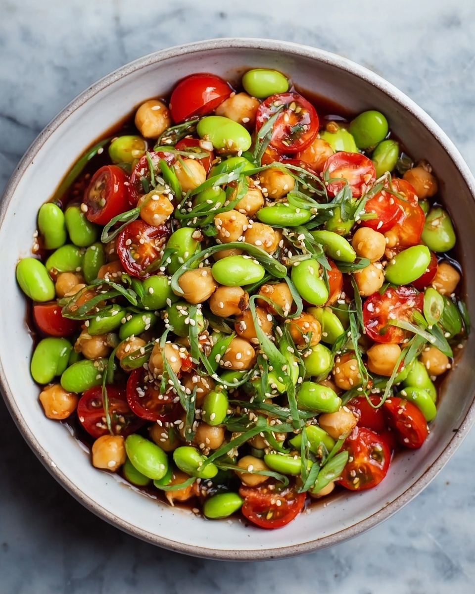 A large white bowl filled with a colorful salad made of several layers: bright green edamame beans and chopped cucumbers form the base, topped with small pieces of red bell pepper and finely shredded orange carrots, with bits of red onion scattered throughout. A woman's hand is holding a glass jar tilted above the salad, pouring a thick, light brown dressing over the fresh vegetables. The background has a white marbled texture with a blurred white bowl holding extra vegetables. photo taken with an iphone --ar 4:5 --v 7