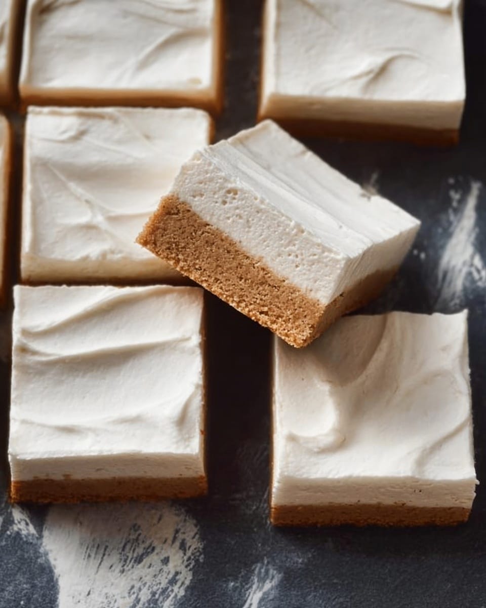 The image shows several square pieces of a two-layer dessert arranged on a dark surface with a white marbled texture. Each piece has a bottom layer that is light brown and slightly dense, resembling a cake or bread texture. The top layer is thick, creamy, and smooth with a white color and soft, swirled patterns on the surface. One piece is slightly tilted, showing a clear side view of the two distinct layers. The overall look is clean and simple, focusing on the contrast between the brown and white layers. Photo taken with an iphone --ar 4:5 --v 7