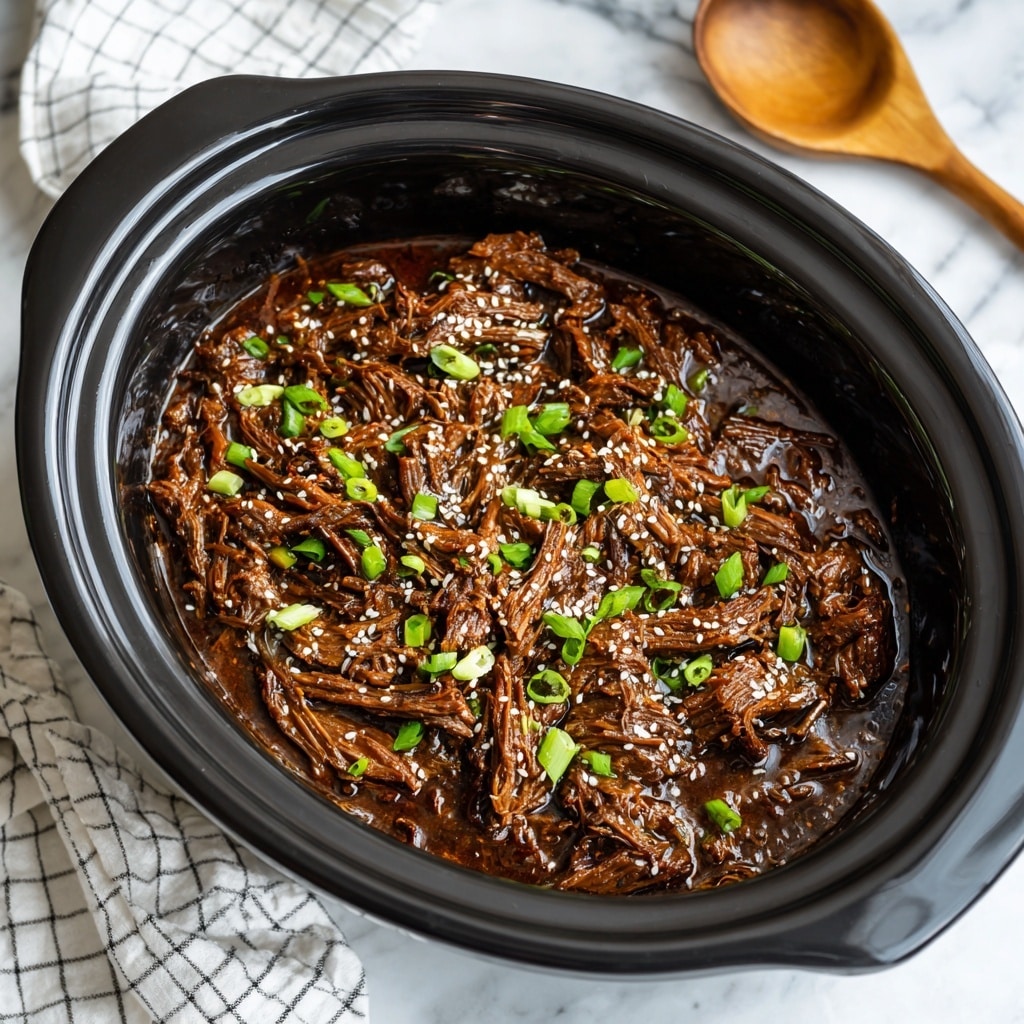 The image shows a black slow cooker pot filled with shredded dark brown beef in a thick glossy sauce. The beef is covered with small white sesame seeds and chopped light green scallions, scattered evenly on the surface. The background has a white marbled texture with a white and black checkered cloth and a wooden spoon visible near the top left side of the cooker. photo taken with an iphone --ar 4:5 --v 7