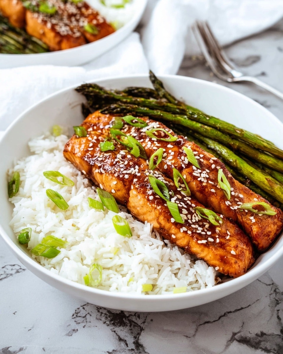 A white bowl contains three layers: the bottom layer is white steamed rice with scattered green onion pieces, the middle layer is dark green grilled asparagus arranged side by side on one half of the bowl, and the top layer has two glazed salmon fillets with a shiny, golden brown surface sprinkled evenly with white sesame seeds and garnished with fresh green onion slices. The bowl is placed on a white marbled surface with a blurred white cloth in the background, and a silver fork can be seen to the right. Photo taken with an iphone --ar 4:5 --v 7