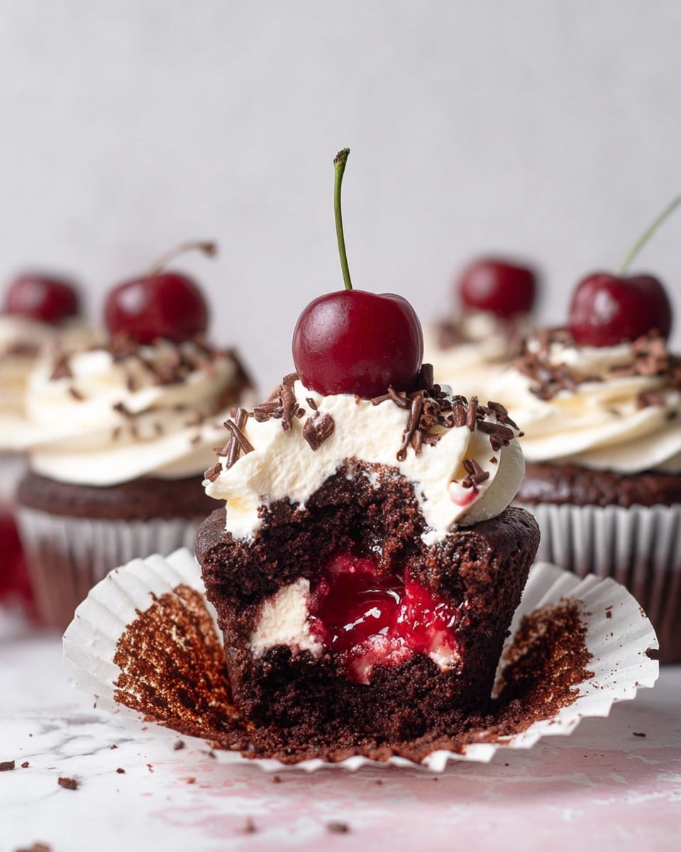 A close-up view of chocolate cupcakes with three clear layers: the dark brown cupcake base has a moist, slightly rough texture; on top, there is a thick swirl of smooth white whipped cream, drizzled with dark red cherry syrup that drips slightly onto the white marbled surface below; finishing the top is a shiny, dark red cherry with its stem, perched neatly on each cupcake; the cupcakes are arranged in a group on a round white marble plate, with some chocolate shavings scattered around and a soft pink background behind, photo taken with an iphone --ar 4:5 --v 7